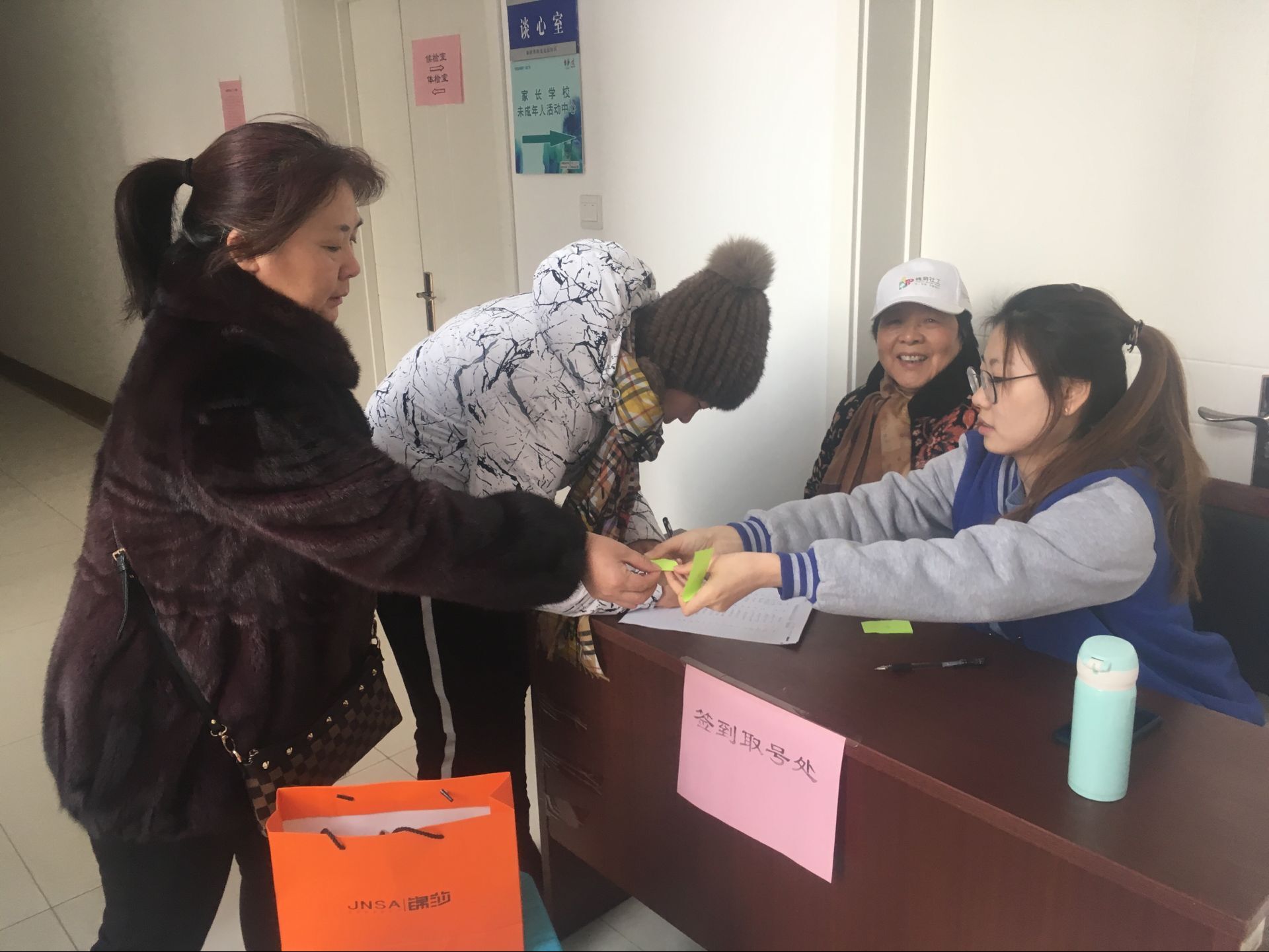 社工和社区志愿者组织居民群众签到取号.jpg